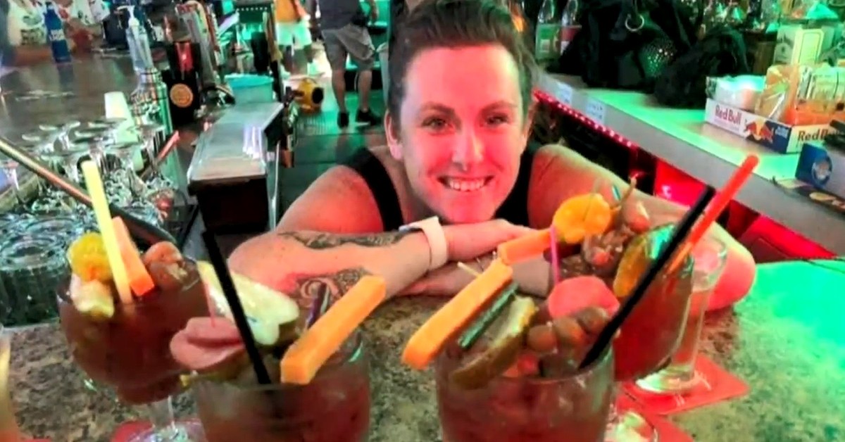 Michelle Hansen before her heart attack, smiling and leaning on a bar full of Bloody Mary drinks.