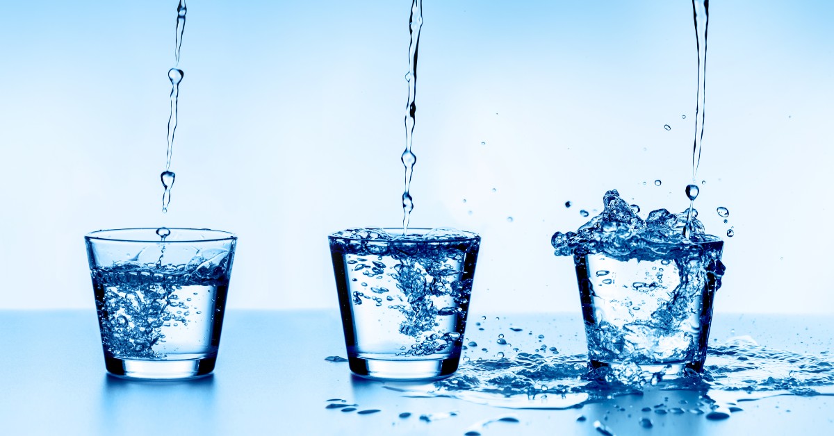 Water pouring from above into three glasses. From left to right, each glass is more full than the previous glass.