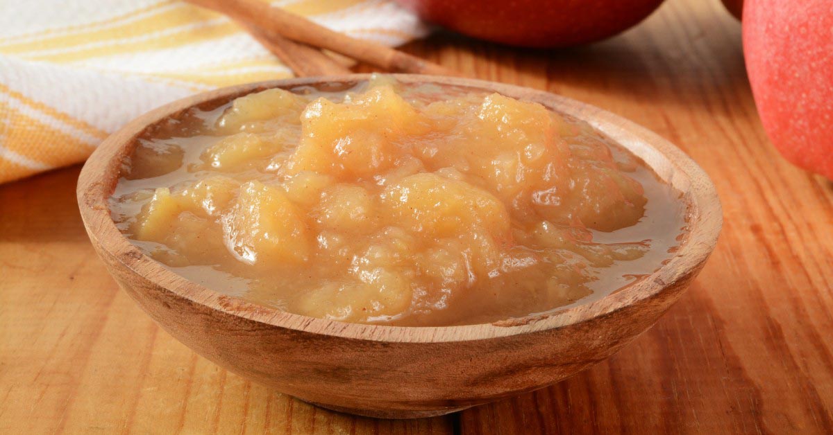 A serving of homemade applesauce in a small wood bowl.