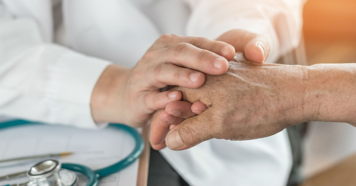 Dr.'s hands holding patient's hands
