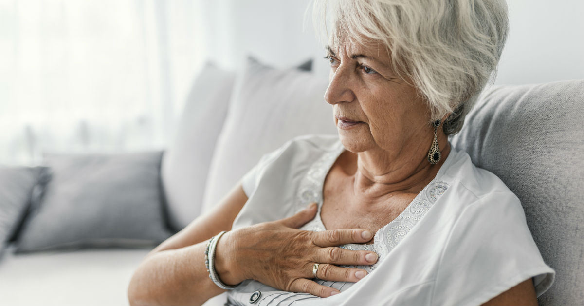 Mature woman with hand held on heart-side of chest